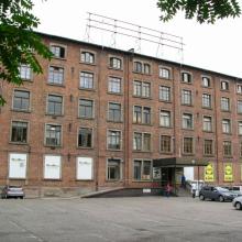Fabrik-Gebäude mit Gerüst der ehem. Landfried-Werbung auf dem Dach