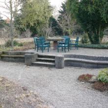 Steinerne Sitzbänke mit Aufgang im Garten