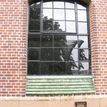 Fenster mit grün glasierten Kacheln an der Fensterbank
