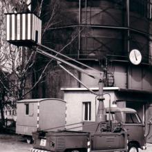 1962: Hubsteiger auf VW-Pritschenwagen vor dem Gaskessel